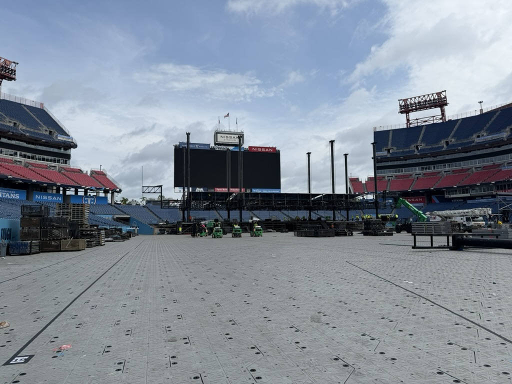 Behind the stage during CMA Fest load-in — cables, equipment cases, and the reality of a major festival build